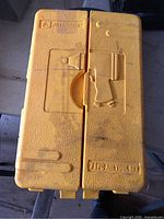 Yellow carry case exterior with embossed tool graphic and Alltrade logo