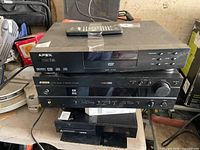Front view showing Apex DVD player stacked on Yamaha receiver with remote on top