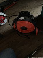 Overall view of black and orange electric blower with power cord