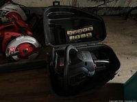 Chainsaw seated inside open hard case, showing tool and interior labels