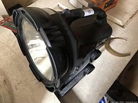 Top angled view of Cyclops handheld floodlight showing lens, handle, support legs