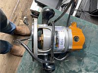 Top view of orange-housed corded wood router with black handles and base