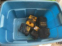 Five DeWalt battery chargers in blue plastic tote