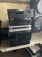 Stacked audio components showing Yamaha receiver on top and Sony components below