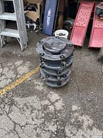 Stack of five garbage can dollies on pavement