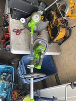 Greenworks string trimmer shaft and hedge trimmer on workbench