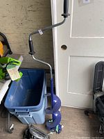 Full view of blue spiral auger with crank handle leaning against wall