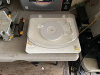 Top view of white Ion record player with clear dust cover on workbench