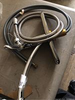 Full view of chrome faucet, pull-out hose, braided supply lines and mounting shank