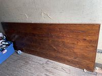 Full view of wooden slab leaning against wall