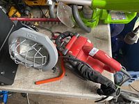 Red Black & Decker belt sander and grey HDX work light on table