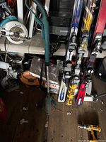 Makita cordless string trimmer shown standing upright among other tools