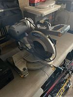 Front angled view of the corded 12-inch Mastercraft Maximum mitre saw on workbench, showing blade guard, base, power cord and adjustment knobs.