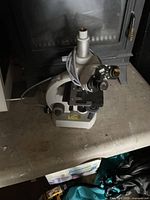 Full view of the microscope showing body, stage, eyepiece, objective turret, and power cord