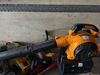 Side view of yellow and black Poulan Pro gas blower with tube attached