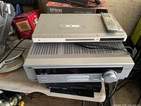 Receiver beneath DVD player with remote on top; shows overall condition and included components.