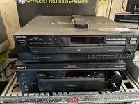 Front view of Sony 5-disc CD changer stacked on Sony AV receiver with remote on top