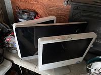 Three Apple iMac computers side-by-side showing front screens