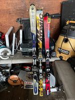 Three pairs of skis standing upright showing graphics and bindings
