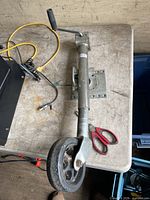 Full view of trailer jack showing mounting plate, crank handle and caster wheel