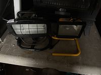 Two halogen work lights on table, showing size, colors and condition