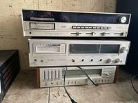 Stack of three stereo receivers: top with 8-track, middle with cassette, bottom JVC with equalizer