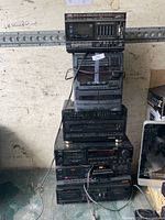 Full view of six stacked stereo components showing brands, controls and condition