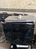 Entire lot showing DVD player on top of stacked Sansui components