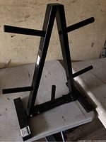 Front angle of black steel A-frame weight plate rack on table