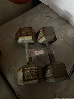 Pair of grey cast-iron 25 lb hex dumbbells with visible rust
