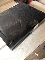 Top and front view of black Microsoft Xbox One console showing overall condition