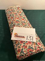 Rolled floral fabric with lot card visible