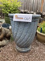 Front view of tall blue glazed ceramic planter in garden setting