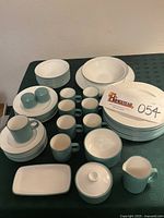 All 47 pieces arranged on table including plates, bowls, cups, serving pieces