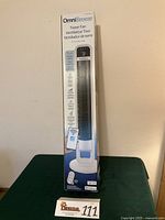 Front view of boxed OmniBreeze CR2032 tower fan