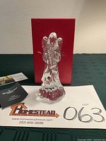 Front view of crystal angel, box and booklet visible