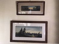 Both paintings framed and hanging on wall next to each other showing size difference and style