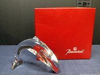 Crystal dolphin figurine displayed alongside red Baccarat box