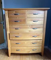 Front view of the wooden chest showing all eight drawers and metal handles.