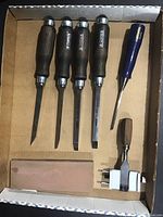 Set of four Narex chisels with wooden handles, one Irwin chisel with blue handle, smaller chisel, sharpening jig and whetstone stone in cardboard box