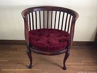 Front view showing barrel-shaped lath back wooden chair with dark finish and tufted burgundy velvet cushion.