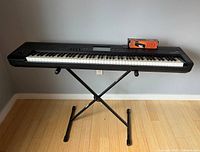 Full front view of Korg Krome keyboard mounted on the Proline X-style stand with Proline sustain pedal box on top.