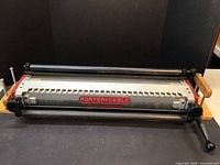 Full view of Porter-Cable dovetail machine showing red body, guide rods, wooden jig and handles
