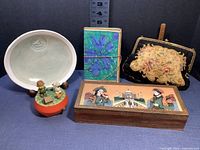 Five items grouped: Lemon Tree Pottery plate, gemstone painting jewelry box, Charlie Brown and Snoopy music box, tapestry purse, and cloth journal.