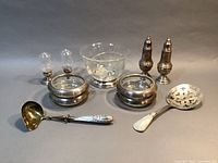 Full set of sterling and etched glass tableware showing bowl, shakers, coasters, ladle, and server.