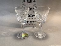 Two Waterford Lismore small cocktail glasses side by side with a size ruler in background to show dimensions.