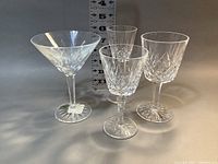 Group photo of four different types of Waterford Lismore crystal glasses showing their shapes and cut pattern with measuring scale in the background.
