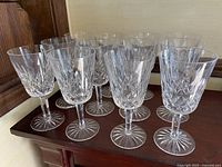 Group view of multiple crystal goblets and claret glasses arranged on a wooden surface
