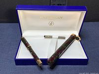 Open presentation box showing fountain pen body, cap, and ink converter inside