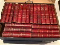 Photo showing all 20 volumes of Waverley Novels in a box, spines facing up, revealing the red leather bindings with gold embossed titles.